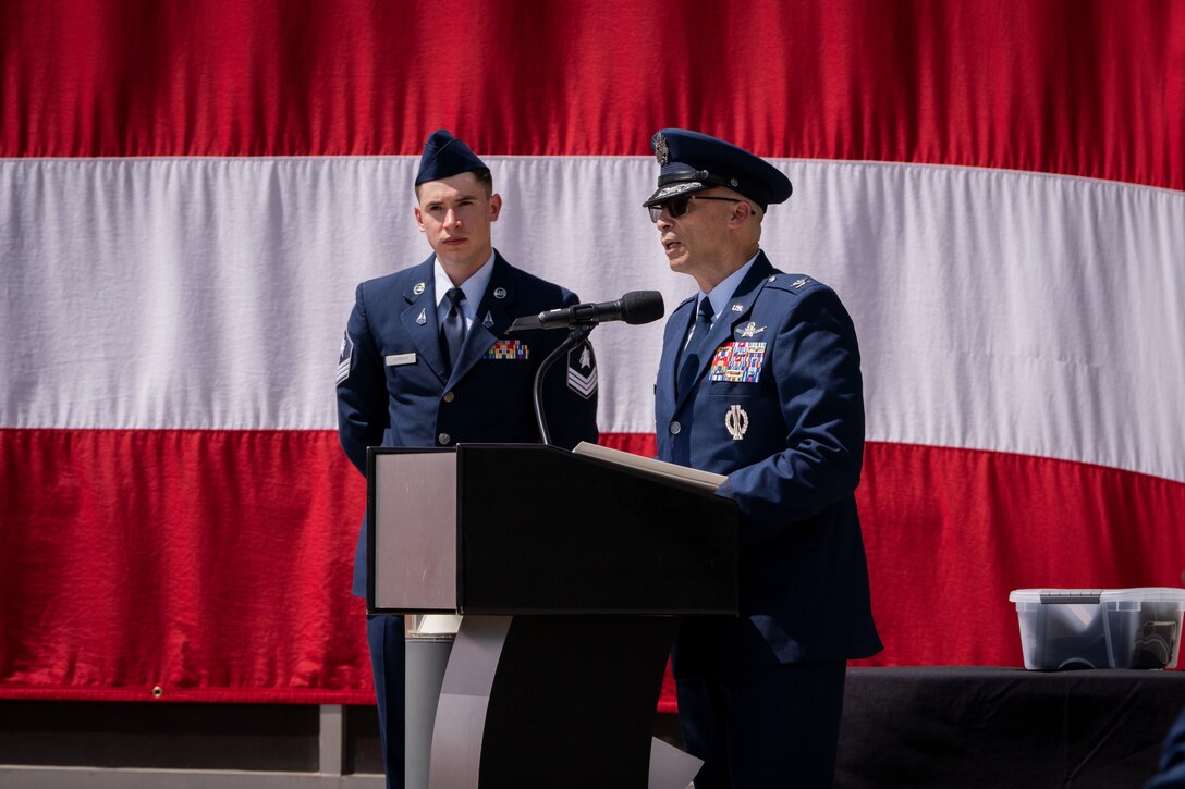 Change of command ceremony with flags and uniformed personnel.