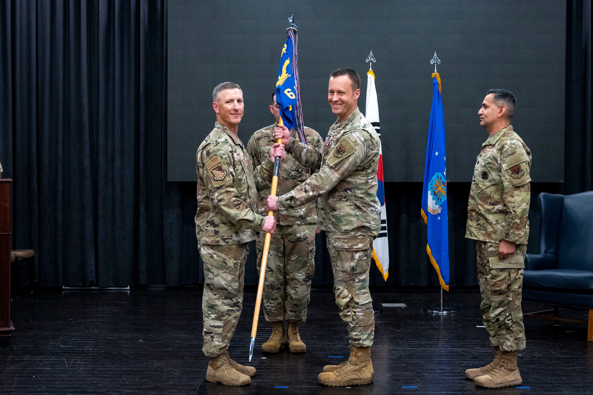 U.S. Air Force Col. Douglas Mabry, left, 694th Intelligence, Surveillance, and Reconnaissance group commander, receives the guidon from Lt. Col. Adam Fossum, right, outgoing 6th Intelligence Squadron commander, at Osan Air Base, Republic of Korea, June 11, 2025.