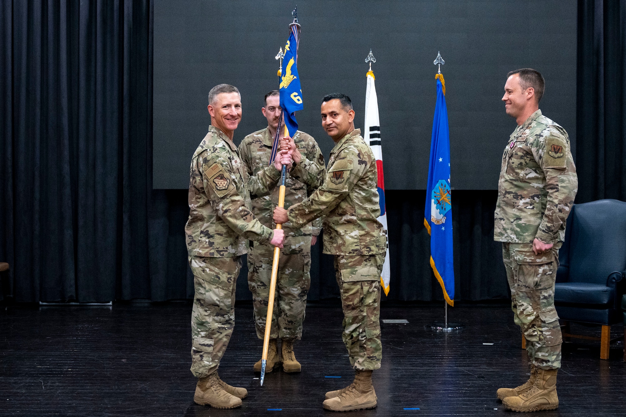 U.S. Air Force Col. Douglas Mabry, left, 694th Intelligence, Surveillance, and Reconnaissance group commander, passes the guidon to Lt. Col. Ryan Tamez, incoming 6th Intelligence Squadron commander, at Osan Air Base, Republic of Korea, June 11, 2025.