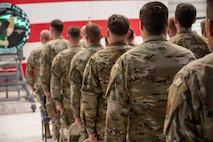 Airmen stand at attention.