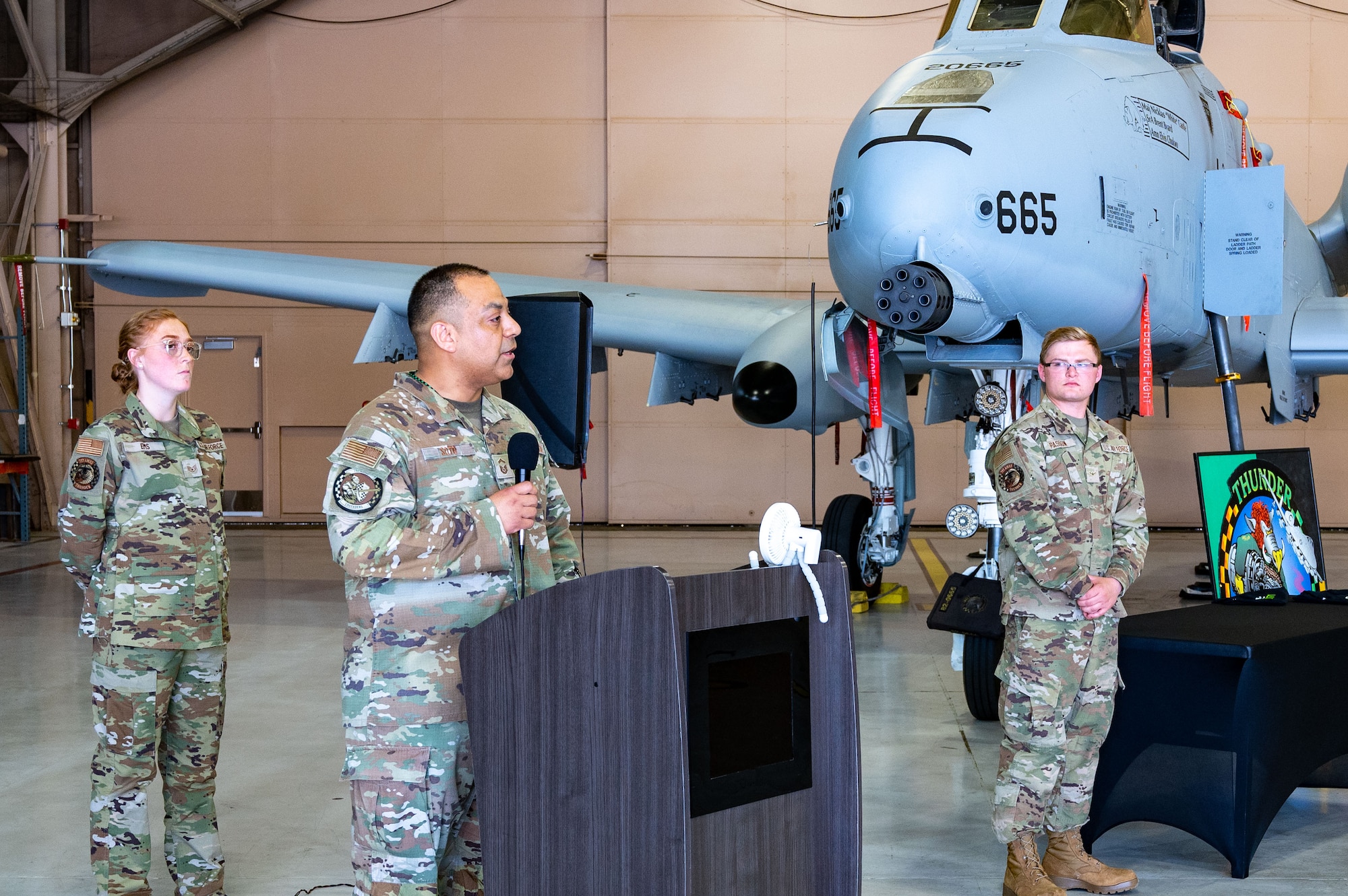 Airmen stand in front of airplane.