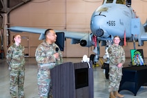 Airmen stand in front of airplane.