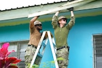 Engineering Aide 2nd Class Jordanne Jones, left, and Construction Electrician 2nd Class Connor Croissant, both assigned to Amphibious Construction Battalion 1, conduct construction repairs at Waiqanake School during Pacific Partnership 2025 in Suva, Fiji, June 9, 2025.