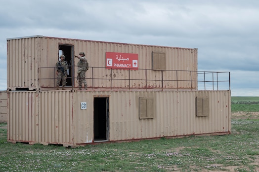  Two security forces members talk while standing atop of a conex box.