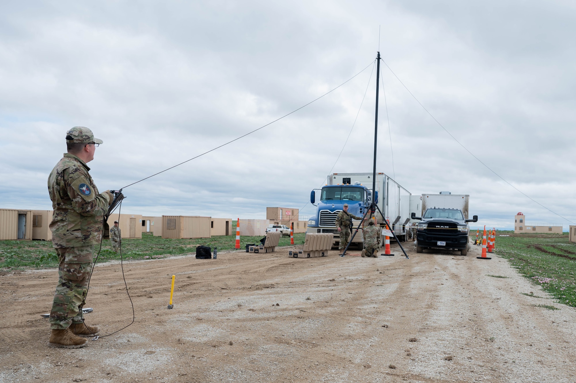 A guardian assists fellow team members as they set up a mobile constellation control station lightning protection system.