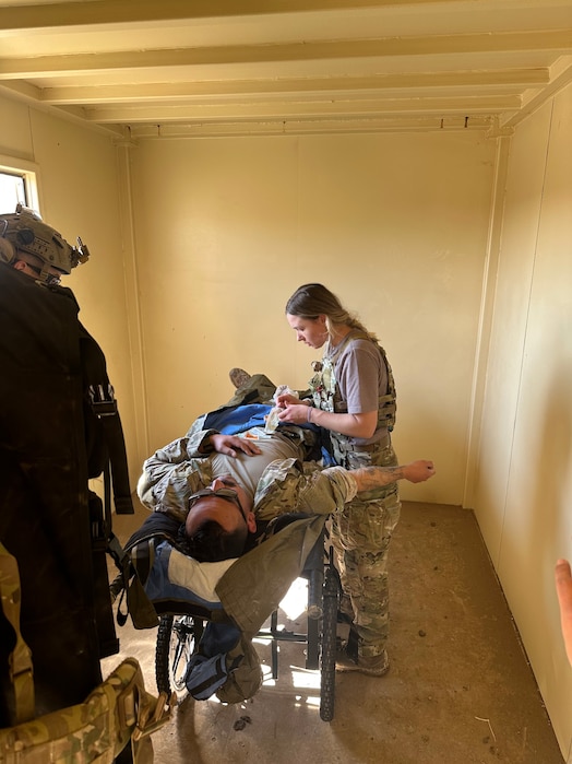  A medical element team member works on a patient in a standup field clinic.