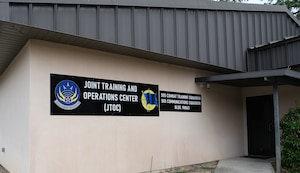 photo of a building with brown signs that have wording “Joint Training and Operations Center (JTOC) and 505th Combat Training Squadron and 505th Communications Squadron”