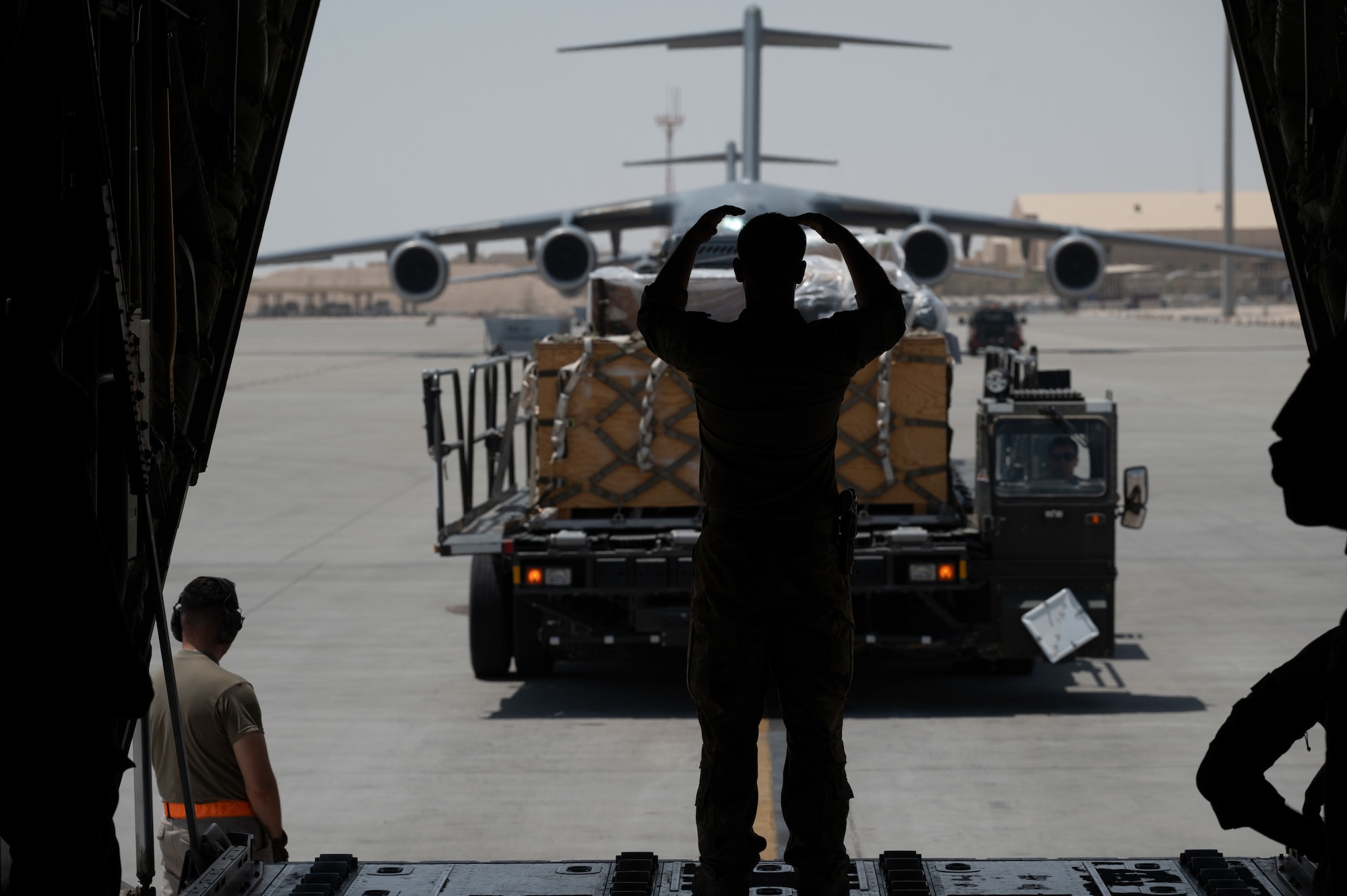 A U.S. Air Force Airman assigned to the 40th Airlift Squadron guides a K-loader towards a C-130J within the U.S. Central Command area of responsibility, June 6, 2025. The 40th AS mission includes transporting personnel, equipment, and supplies and supporting humanitarian and contingency operations across the globe. (U.S. Air Force photo by Senior Airman Dieondiere Jefferies)