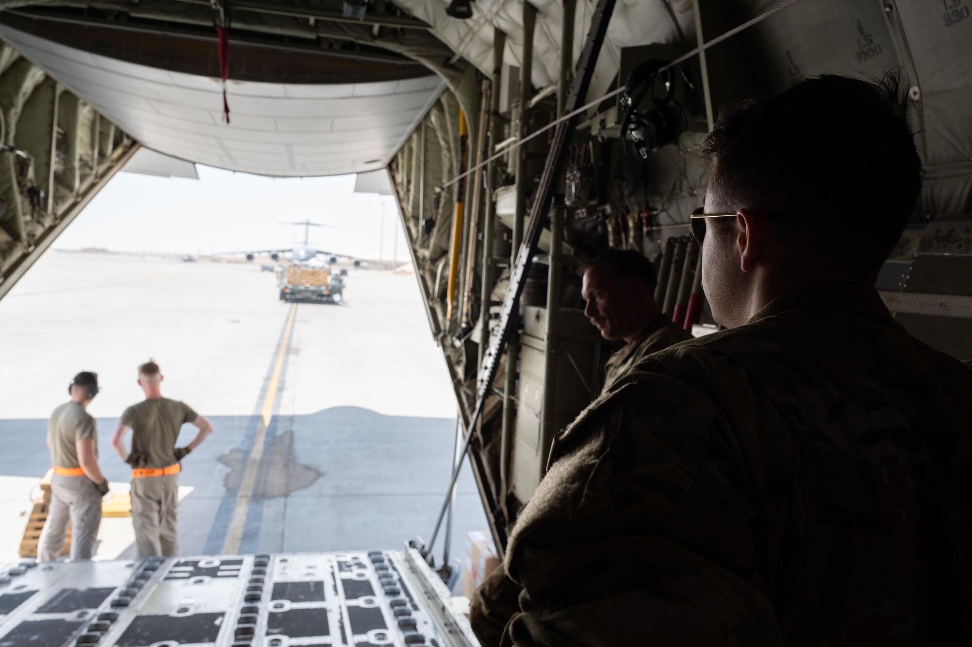 U.S. Air Force 1st Lieutenant Trevor Foutz, 40th Airlift Squadron pilot, waits for a K-loader before loading cargo onto a C-130J within the U.S. Central Command area of responsibility, June 6, 2025. The aircraft is capable of operating from rough terrain and is historically known for airdropping troops and equipment into hostile areas. (U.S. Air Force photo by Senior Airman Dieondiere Jefferies)