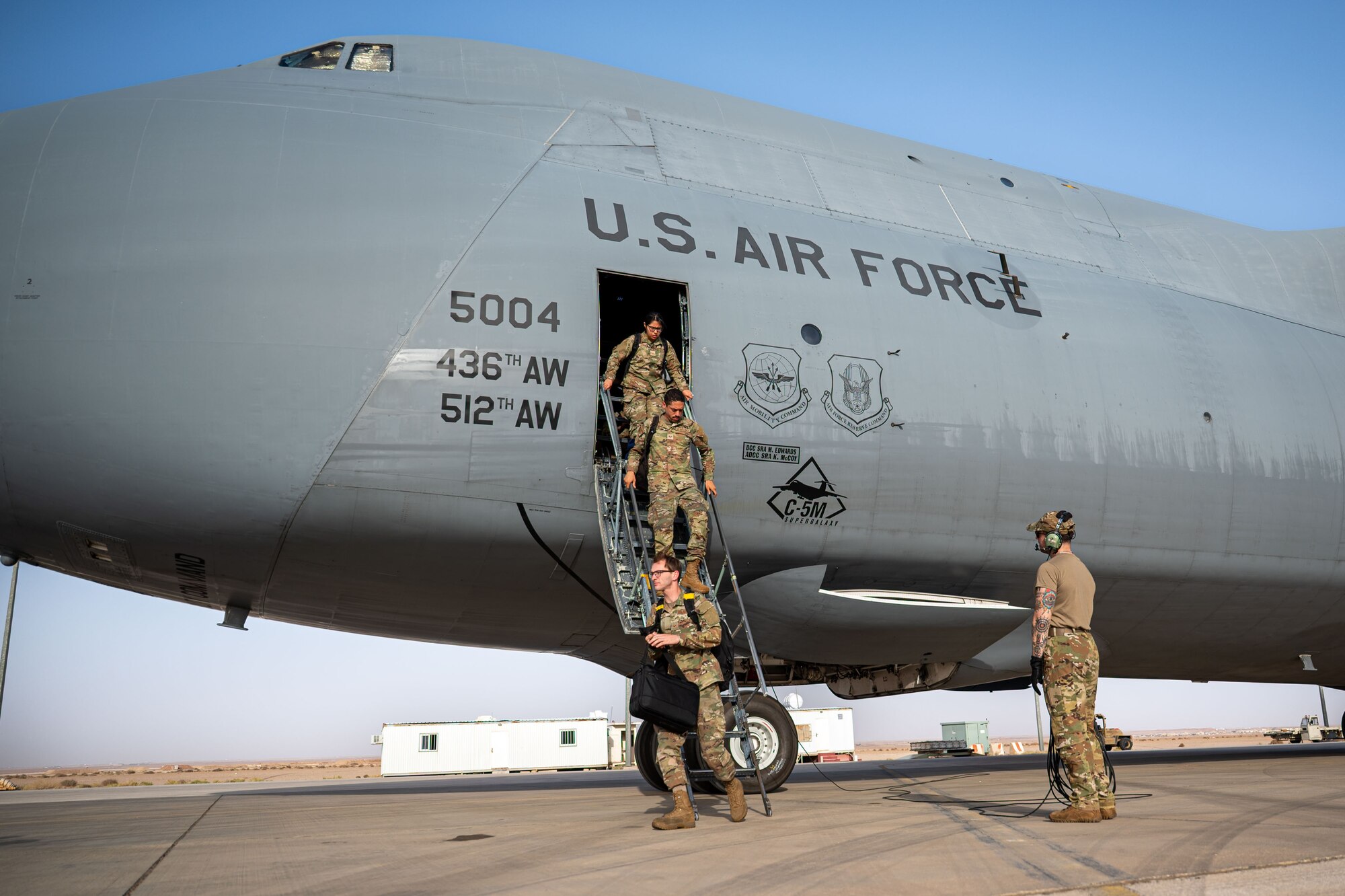 Airmen exit a plane.