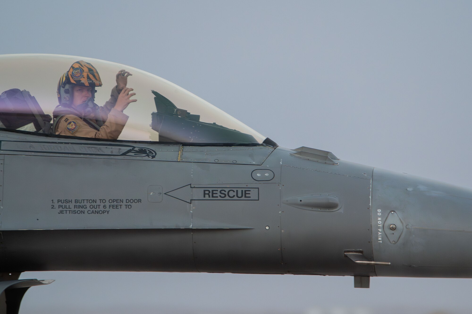 A pilot makes a tiger claw hand gesture.