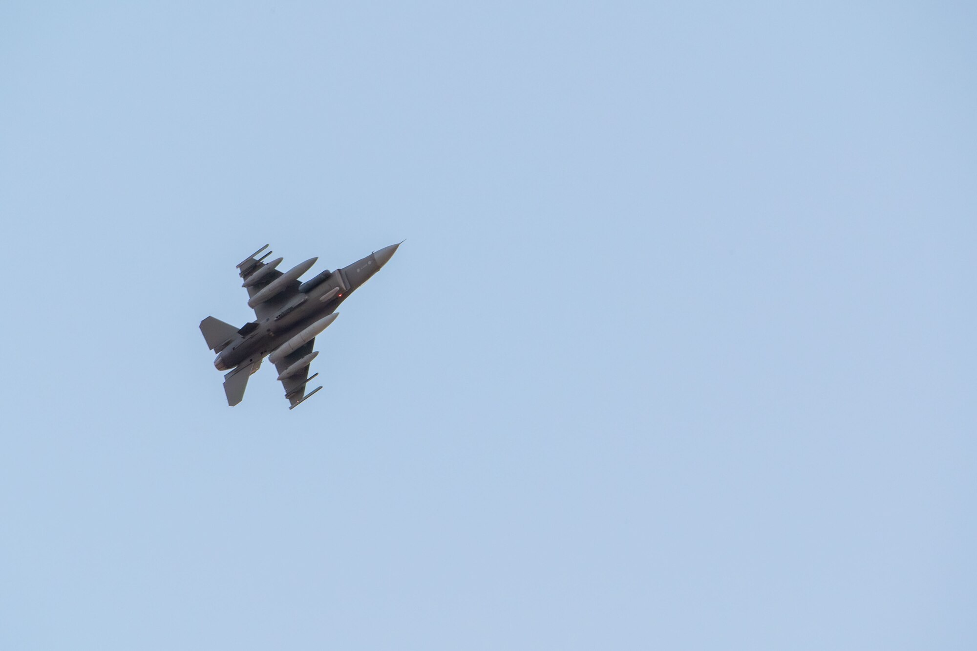 A F-16C Fighting Falcon flies overhead.