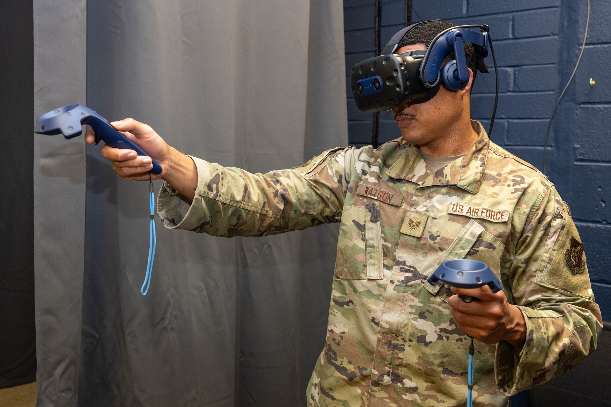 Airman using VR headset and joysticks.