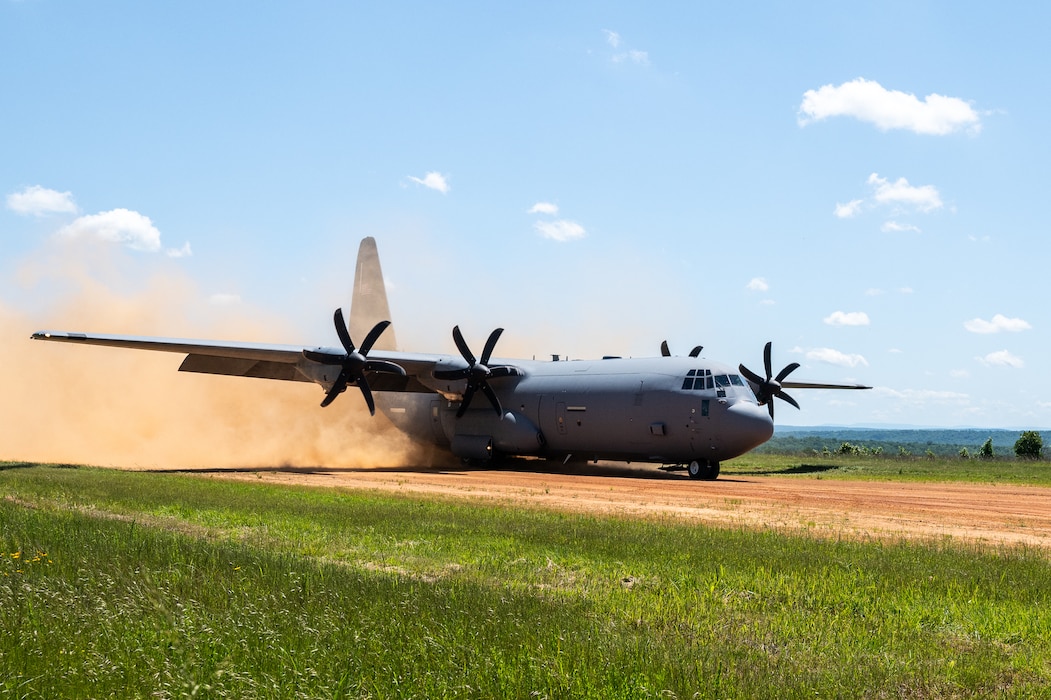 A C-130J Super Hercules performs a touch-and-go on a dirt runway