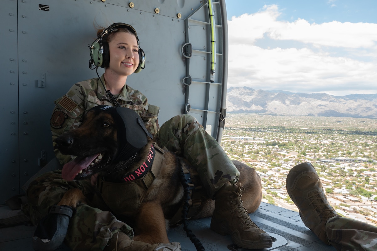 Senior Airman Kimbree Rush, 355th Security Forces Squadron military working dog handler, comforts a MWD on board an HH-60W Jolly Green II helicopter above Tucson, Ariz., June 3, 2025. Rush spent 20 minutes in the air with her MWD flying above Tucson to become comfortable on board the helicopter. (U.S. Air Force photo by Airman Jaden Kidd)