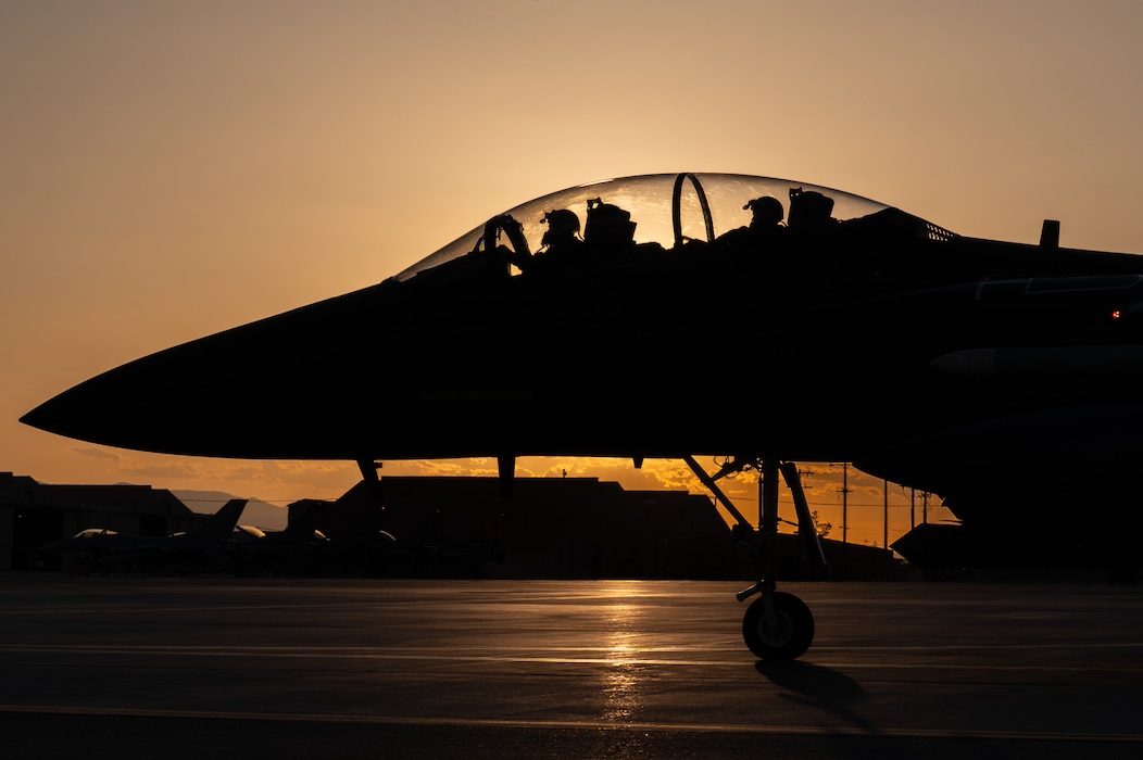 F-15 on flightline backlit by sun