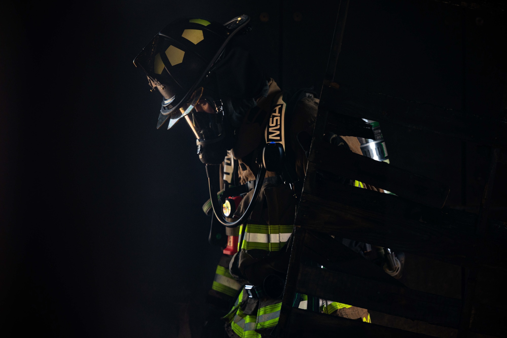 Firefighter in dark room with only high visibility reflectors showing