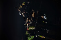 Firefighter in dark room with only high visibility reflectors showing