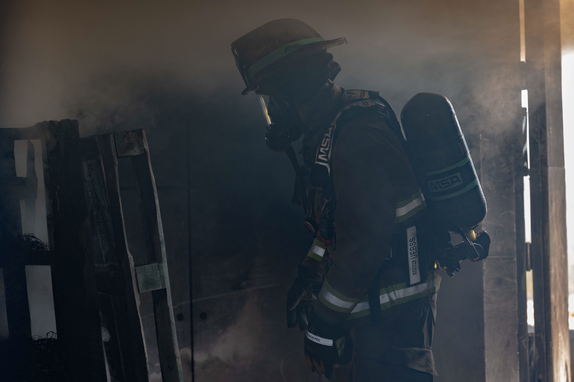Firefighter walking in structure with surrounding smoke