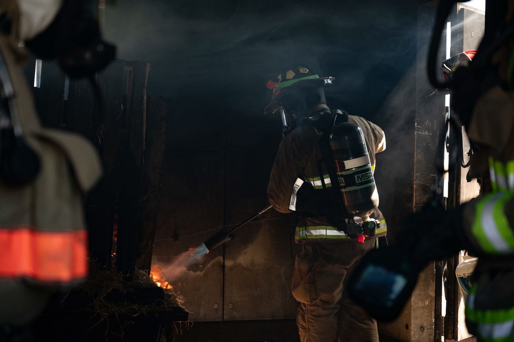 Firefighter ignites a pile of kindling inside a structure