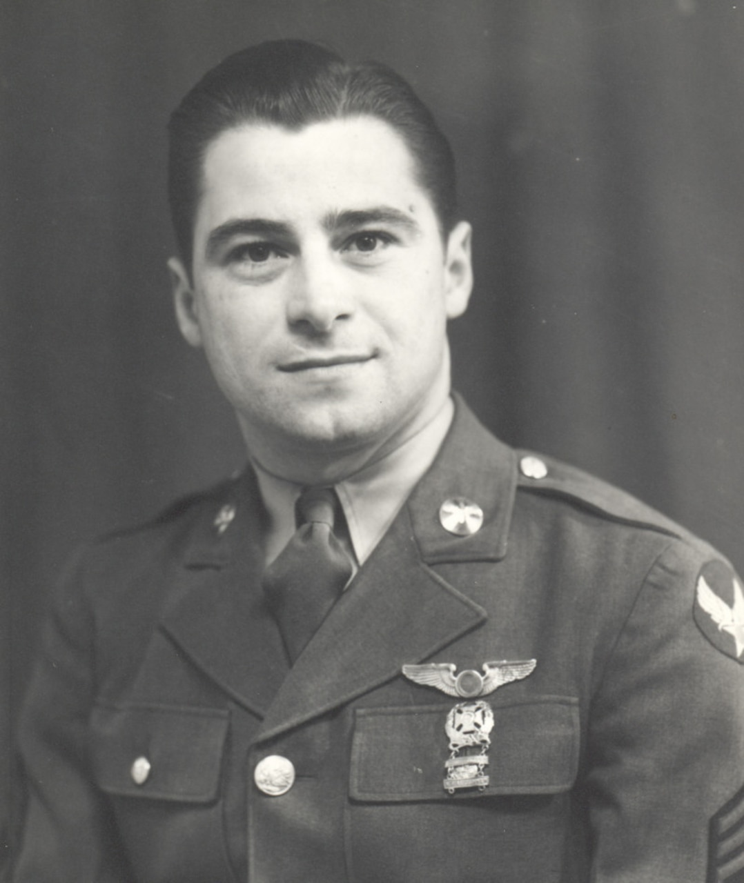 A man in a military dress uniform smiles for a photo.