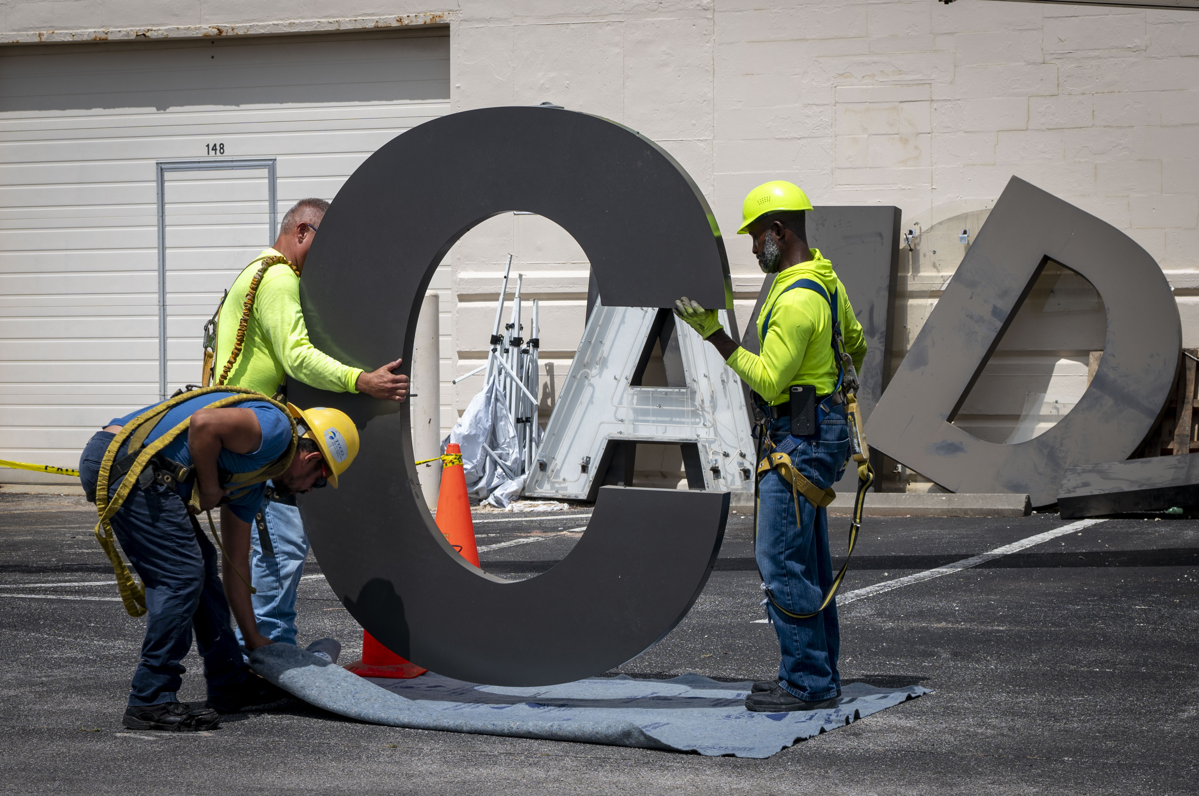 Electricians with Mark One Power prepare to install the letter “C” on Hangar 3 at MacDill Air Force Base, Florida, June 6, 2025. The previous letter was blown off the hangar during Hurricane Helene, a Category 4 hurricane that struck the region in September 2024. Since then, extensive repairs have been completed, with the recent restoration of the iconic MacDill AFB sign symbolizing the base’s recovery from the hurricanes. (U.S. Air Force photo by Airman 1st Class Alicia Campbell)