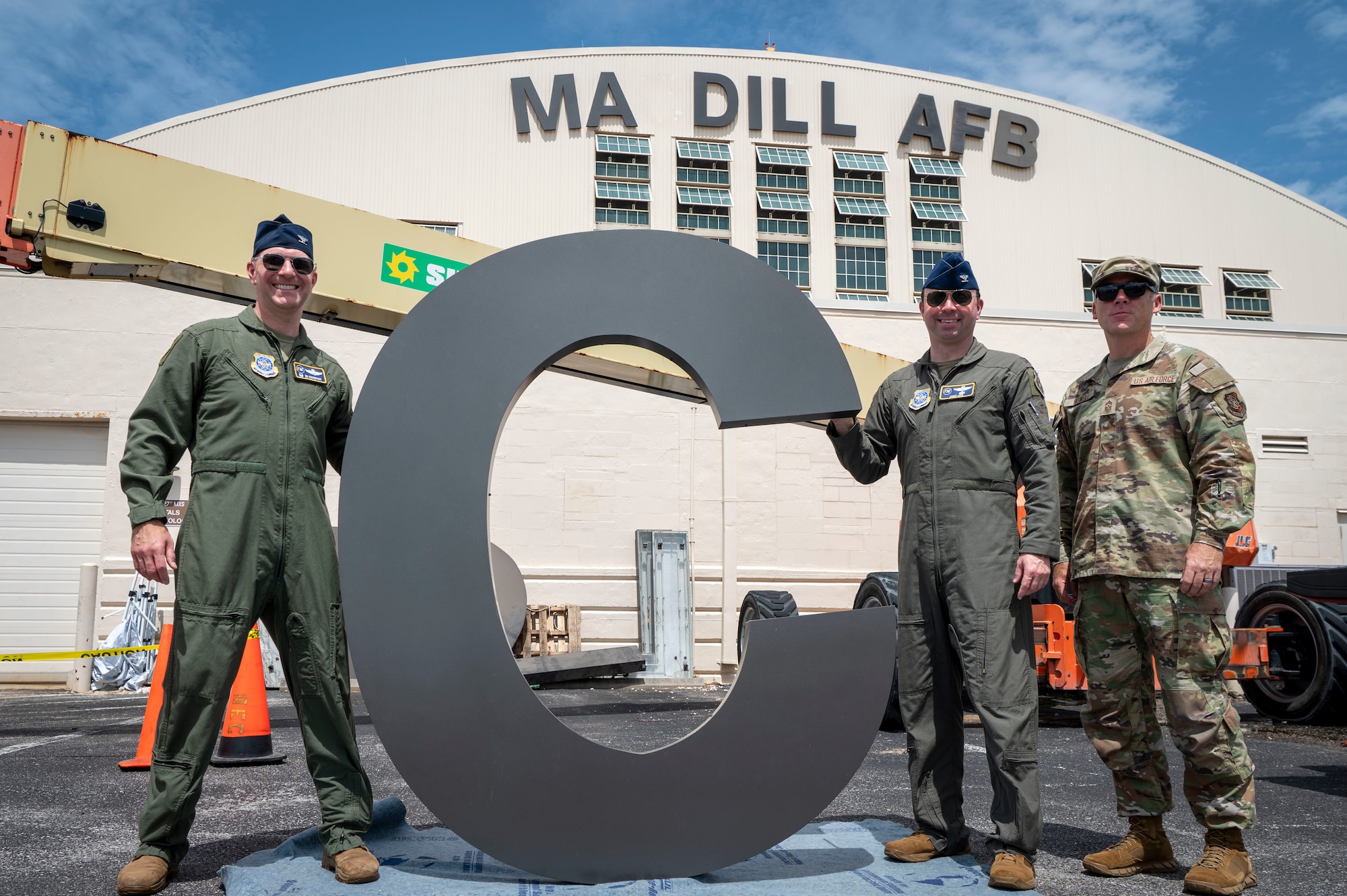 From left, U.S. Air Force Col. Edward Szczepanik, 6th Air Refueling Wing commander, Col. James Long, 6th ARW deputy commander, and Chief Master Sgt. Raun Howell, 6th ARW command chief, hold up the letter “C” before it is installed on Hangar 3 at MacDill Air Force Base, Florida, June 6, 2025. The previous letter was blown off the hangar during Hurricane Helene, a Category 4 hurricane that struck the region in September 2024. Since then, extensive repairs have been completed, with the recent restoration of the iconic MacDill AFB sign symbolizing the base’s recovery from the hurricanes. (U.S. Air Force photo by Airman 1st Class Alicia Campbell)