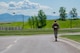 Airman with ruck sack running with two helicopters in the background.
