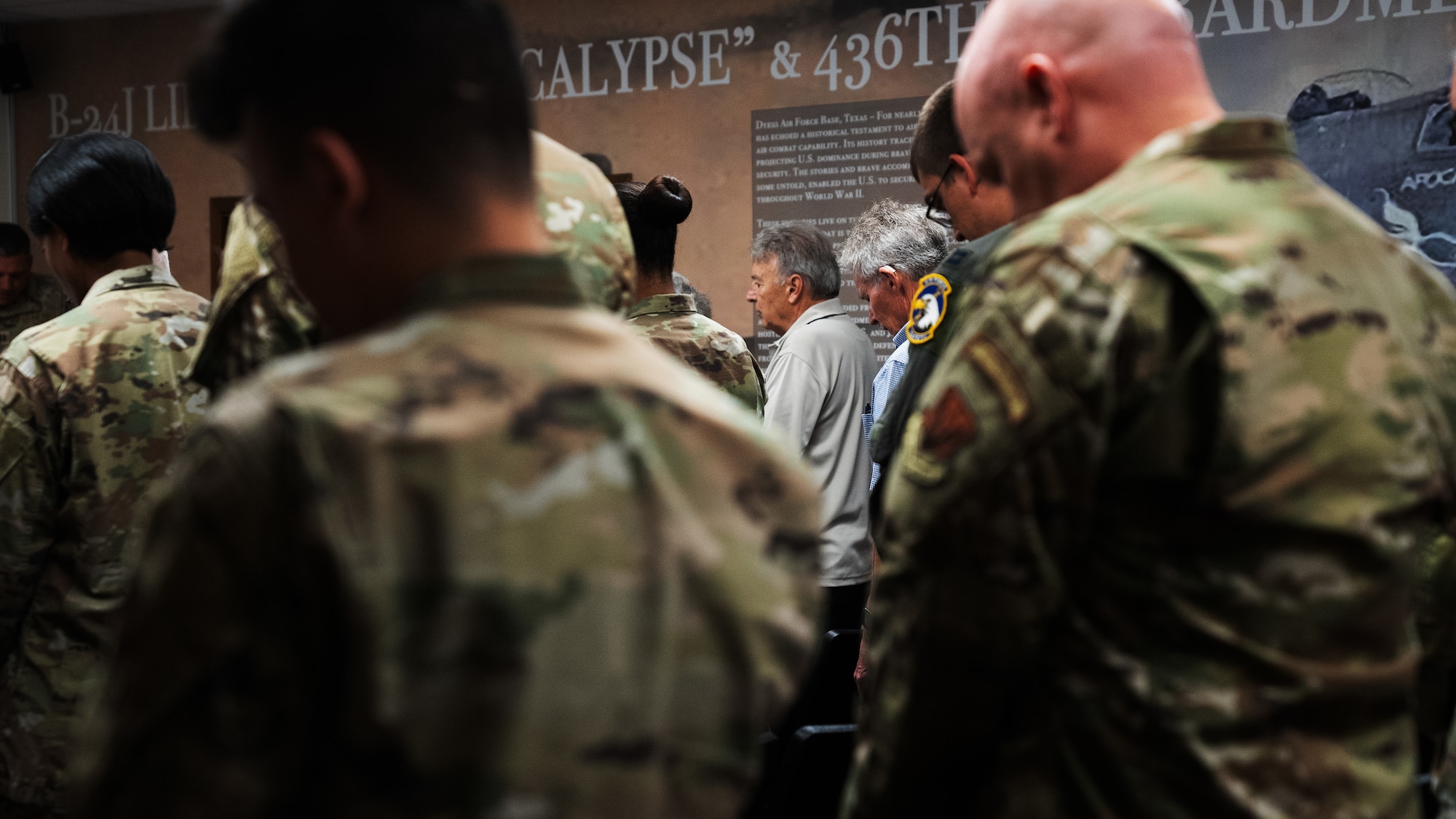 Airmen and families pause for an invocation during an auditorium dedication ceremony at the 436th Training Squadron, June 2, 2025, at Dyess Air Force Base, Texas. The 436th TRS auditorium was named "Apocalypse Hall" after U.S. Army Air Corps members 2nd Lt. John E. McLauchlen, Tech Sgt. Harold L. Seifried and Staff Sgt. Frank J. Tedone who were crewmembers at the start of World War II attached to the 436th Bombardment Squadron.  All three men lost their lives when the B-24J Liberator “Apocalypse” was shot down in the Southwest Pacific. (U.S. Air Force photo by Master Sgt. Eboni Reams)