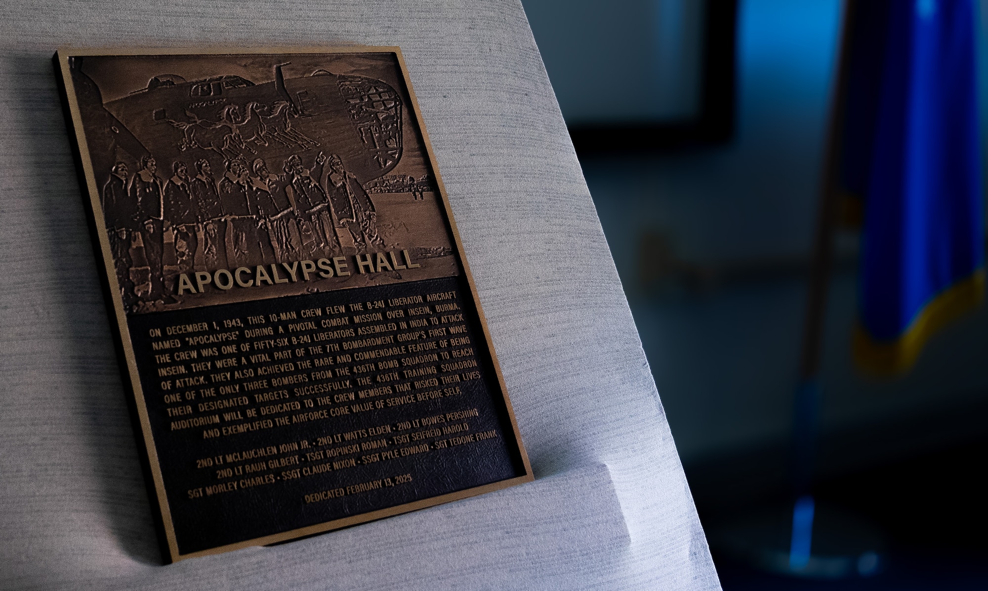 An unveiled plaque rests on the stage of the newly dedicated Apocalypse Hall at the 436th Training Squadron, June 2, 2025, at Dyess Air Force Base, Texas. he 436th TRS auditorium was named "Apocalypse Hall" after U.S. Army Air Corps members 2nd Lt. John E. McLauchlen, Tech Sgt. Harold L. Seifried and Staff Sgt. Frank J. Tedone who were crewmembers at the start of World War II attached to the 436th Bombardment Squadron.  All three men lost their lives when the B-24J Liberator “Apocalypse” was shot down in the Southwest Pacific. (U.S. Air Force photo by Master Sgt. Eboni Reams)