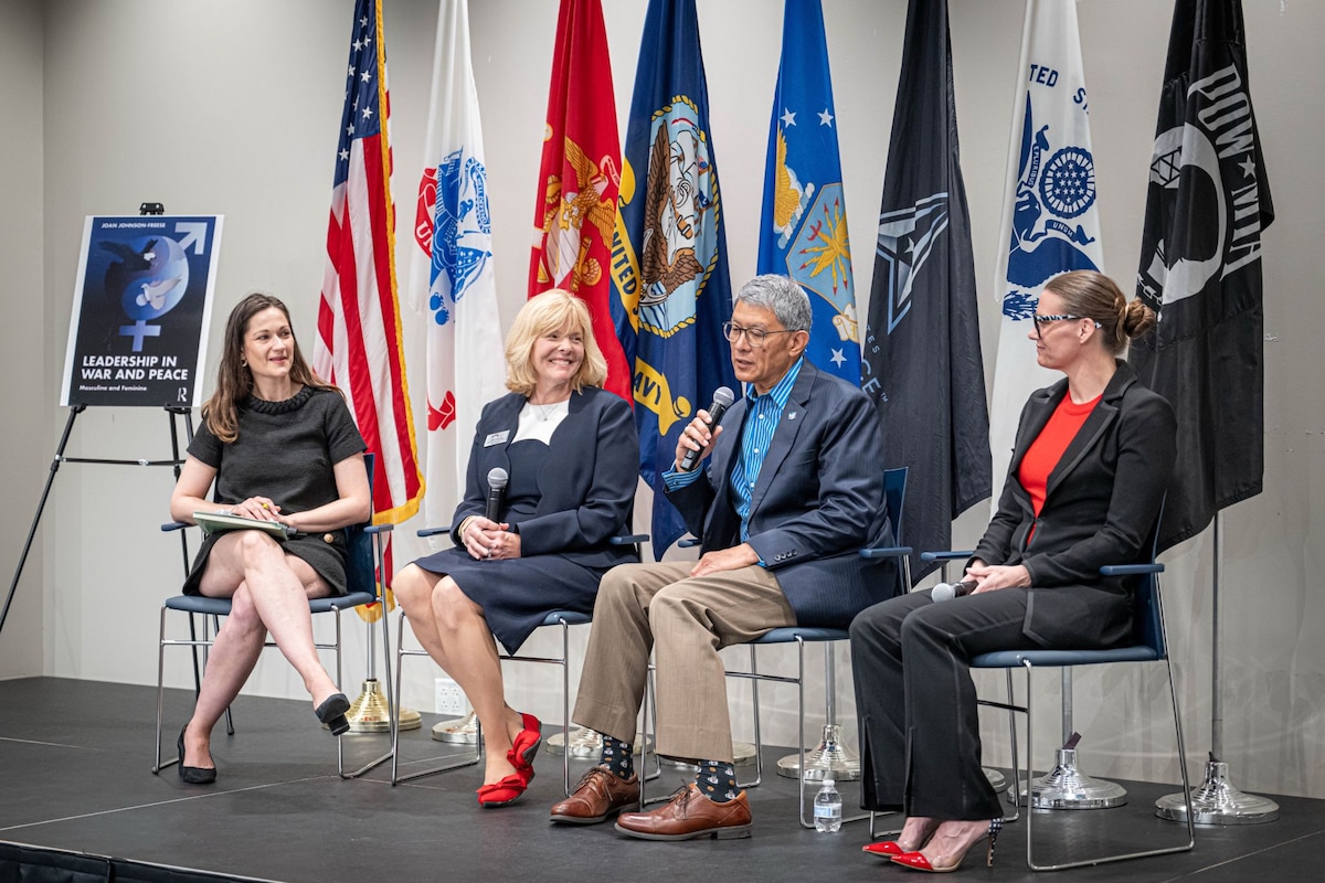 Image of people talking on a panel while sitting down.