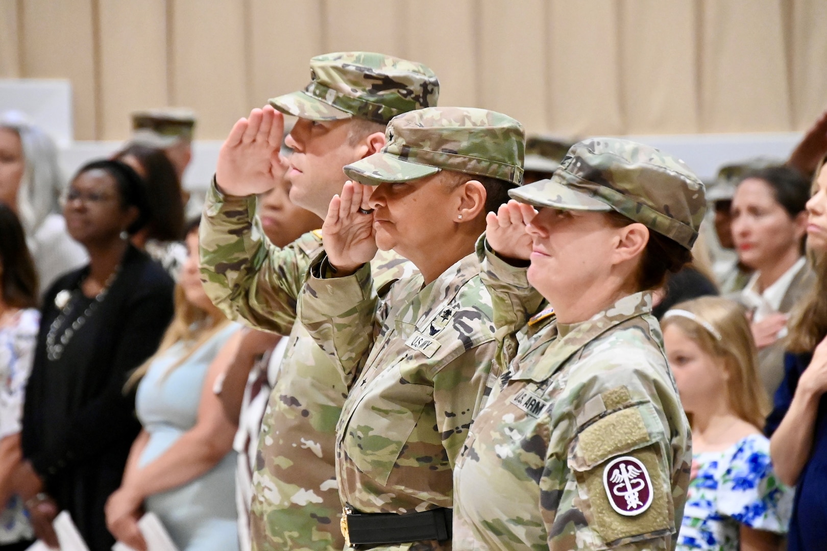Three leaders lined up presenting arms as the National Anthem is played during the change of command ceremony.