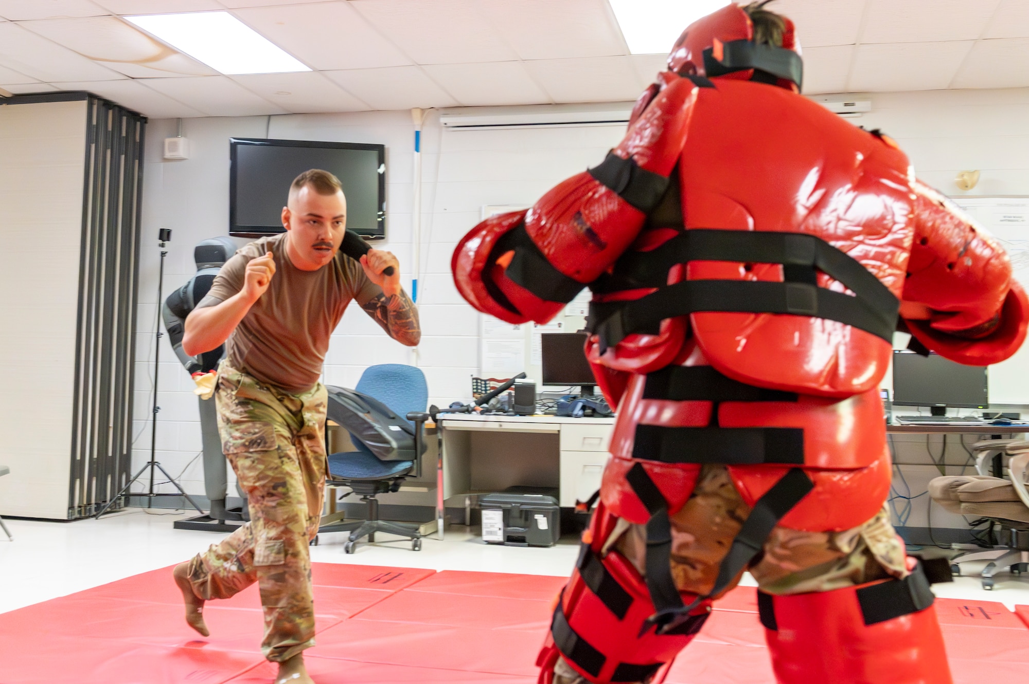 a man engages in hand to hand combat with another man in protective gear
