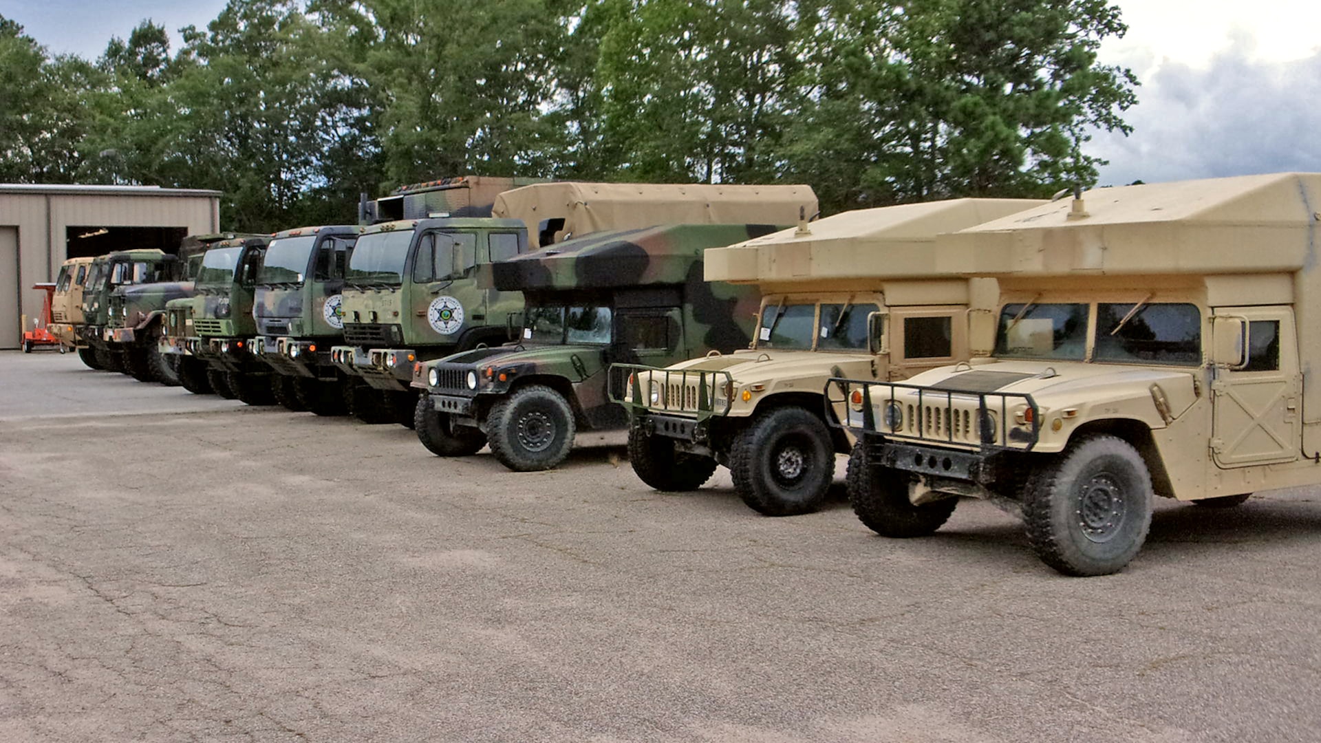 Large vehicles lined up in an outdoor lot.