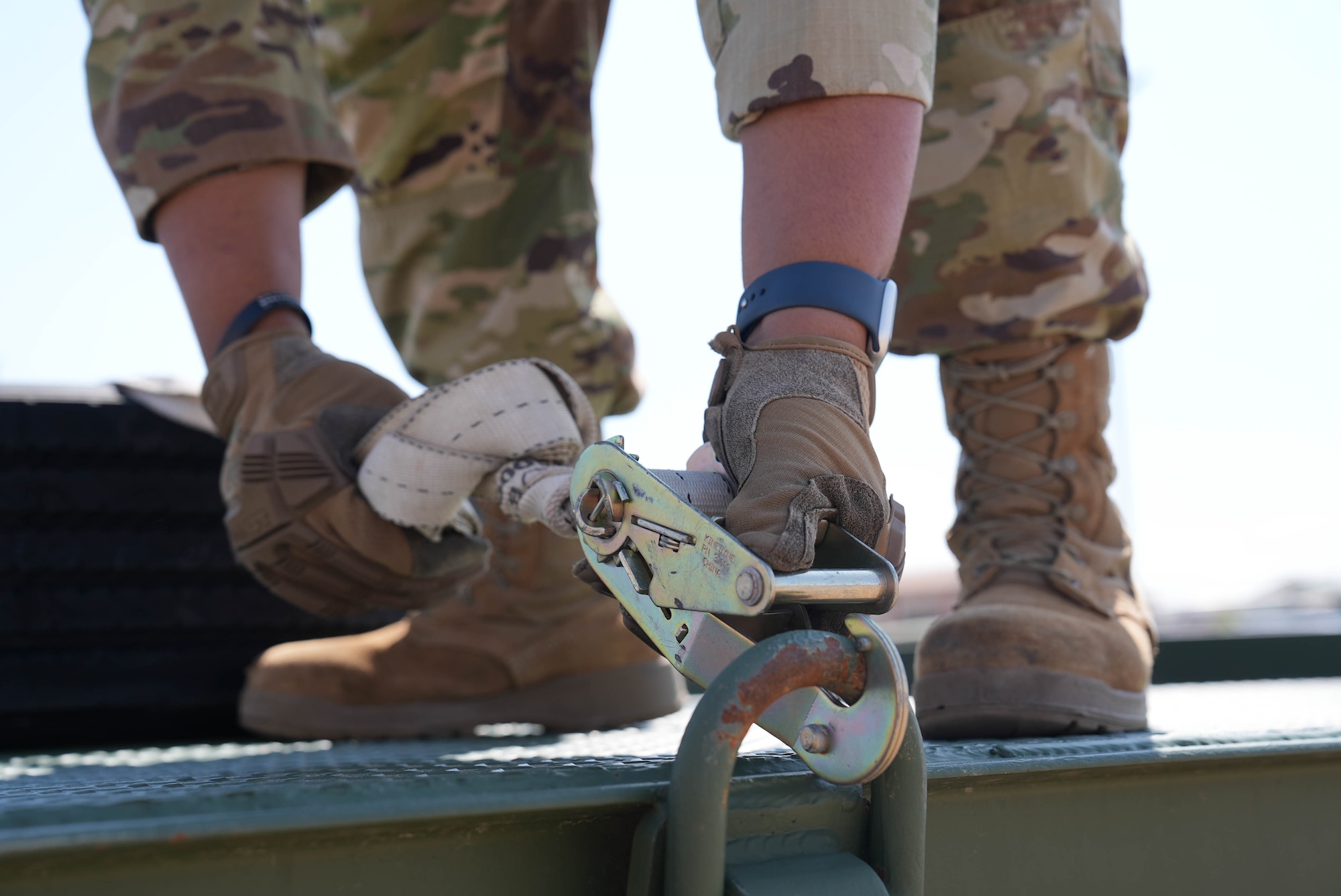 A ground transportation specialist assigned to the 27th Special Operations Wing uses a ratchet strap to secure a spare tire to a flatbed trailer at Cannon Air Force Base, New Mexico, June 4, 2025. An increase in the number of active commercial driver licenses across the wing will help better support transportation requests, streamlining logistics for all units assigned to the 27th SOW. (U.S. Air Force photo by Staff Sgt. Kevin Williams)