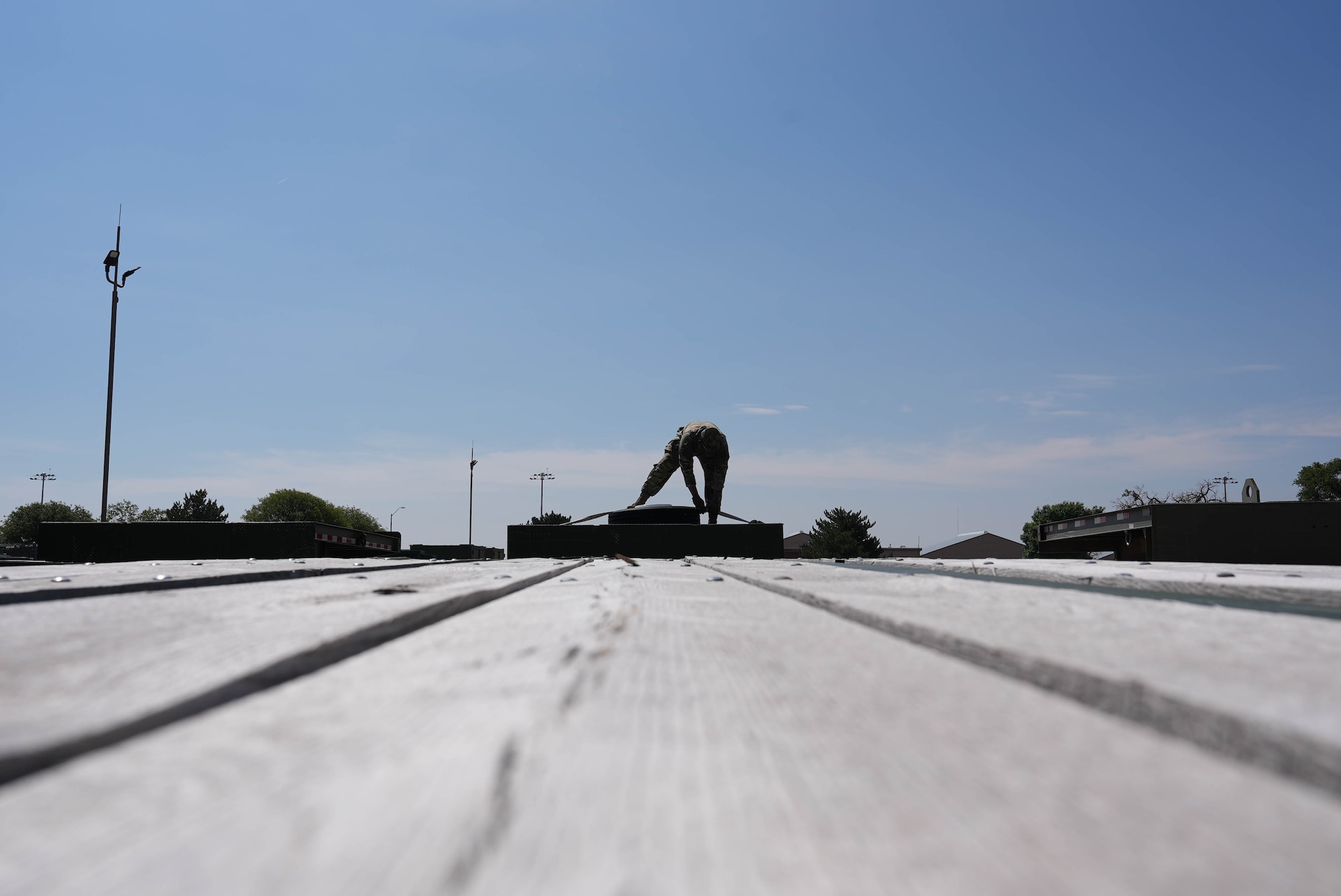 A ground transportation specialist assigned to the 27th Special Operations Wing secures a spare tire to a flatbed trailer at Cannon Air Force Base, New Mexico, June 4, 2025. As Air Force Special Operations Command’s premier readiness wing, the 27th SOW’s mission depends upon the capability for personnel, munitions, and other cargo to be moved and loaded at a moment’s notice. (U.S. Air Force photo by Staff Sgt. Kevin Williams)