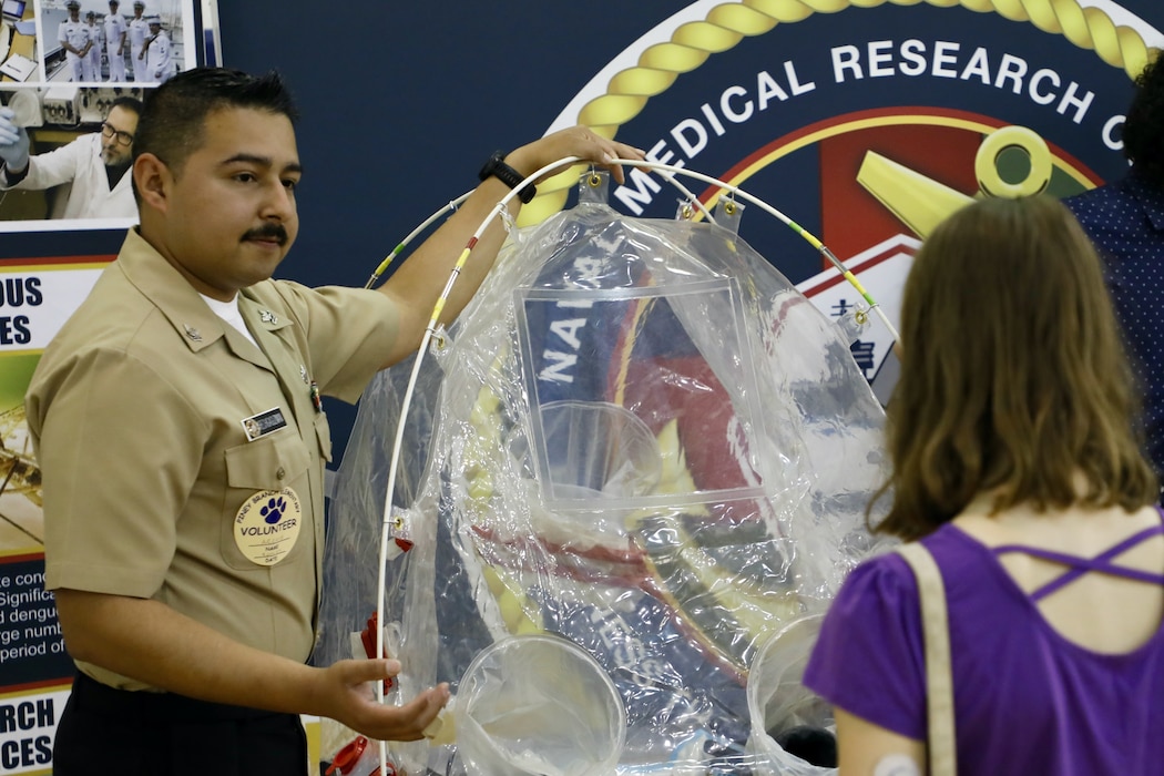TAKOMA, Md. (June 09, 2025) Hospital Corpsman 2nd class Gilberto Arechigaguzman, with Naval Medical Research Command (NMRC), engages with students at Piney Branch Elementary School about work done by and career opportunities in the Navy and in Medical Research. Piney Branch students had the opportunity to speak with active-duty Sailors and command scientists during the event. NMRC, headquarters of NMR&D, is engaged in a broad spectrum of activity from basic science in the laboratory to field studies in austere and remote areas of the world to investigations in operational environments. In support of Navy, Marine Corps and joint U.S. warfighter health, readiness and lethality, researchers study infectious diseases, biological warfare detection and defense, combat casualty care, environmental health concerns, aerospace and undersea medicine, operational mission support and epidemiology. For 250 years, Navy Medicine, represented by more than 44,000 highly-trained military and civilian healthcare professionals, has delivered quality healthcare and enduring expeditionary medical support to the warfighter on, below, and above the sea and ashore. (U.S. Navy photo by Elliott Page /Released)