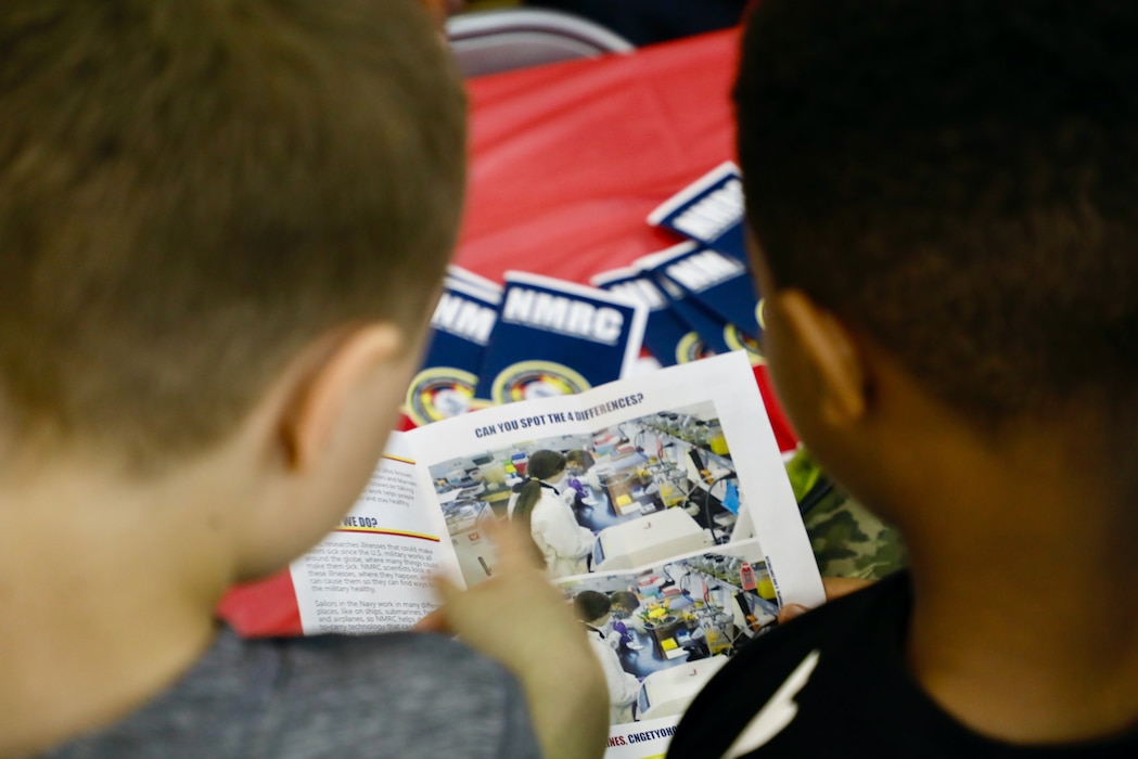 TAKOMA, Md. (June 09, 2025) Students at Piney Branch Elementary School read about Naval Medical Research Command (NMRC) at the command’s booth during a career day event. Piney Branch students had the opportunity to speak with active-duty Sailors and command scientists to learn about career opportunities in research and in the U.S. Navy during the event. NMRC, headquarters of NMR&D, is engaged in a broad spectrum of activity from basic science in the laboratory to field studies in austere and remote areas of the world to investigations in operational environments. In support of Navy, Marine Corps and joint U.S. warfighter health, readiness and lethality, researchers study infectious diseases, biological warfare detection and defense, combat casualty care, environmental health concerns, aerospace and undersea medicine, operational mission support and epidemiology. For 250 years, Navy Medicine, represented by more than 44,000 highly-trained military and civilian healthcare professionals, has delivered quality healthcare and enduring expeditionary medical support to the warfighter on, below, and above the sea and ashore. (U.S. Navy photo by Elliott Page /Released)