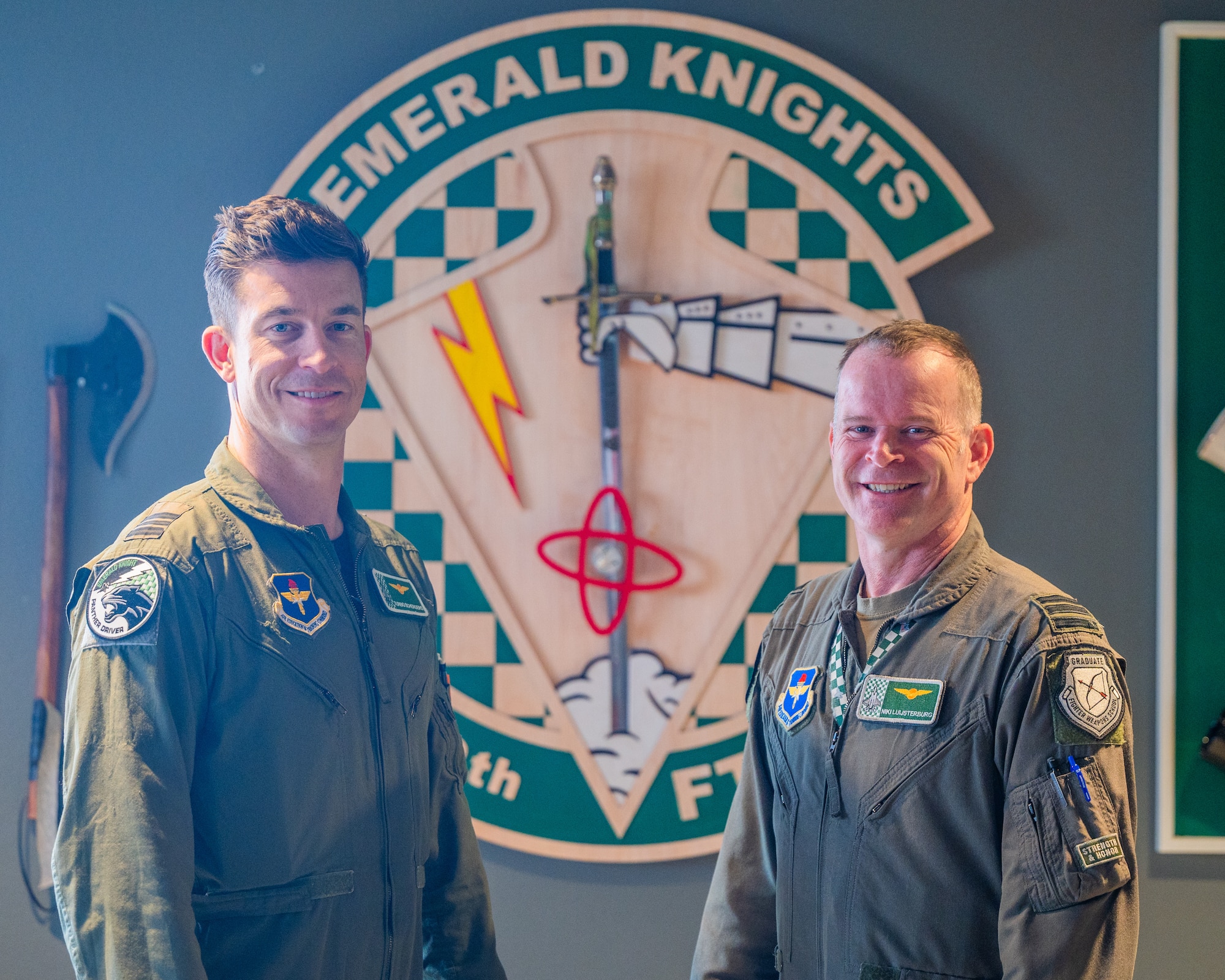 Royal Netherlands Air Force Maj. Rolandus Scherders (left), RNLAF 312th Squadron director of operations, and RNLAF Lt. Col. Joseph Luijsterburg (right), 308th Fighter Squadron Dutch detachment commander, stand in front of the 308th Fighter Squadron seal, June 11 2025, Luke Air Force Base, Arizona.
