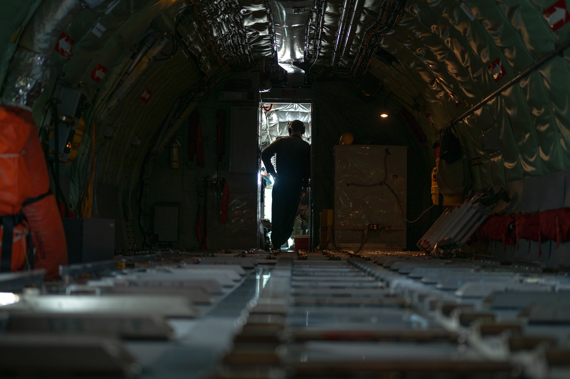 a military member waits in the doorway of the cockpit inside of a  KC-135 Stratotanker
