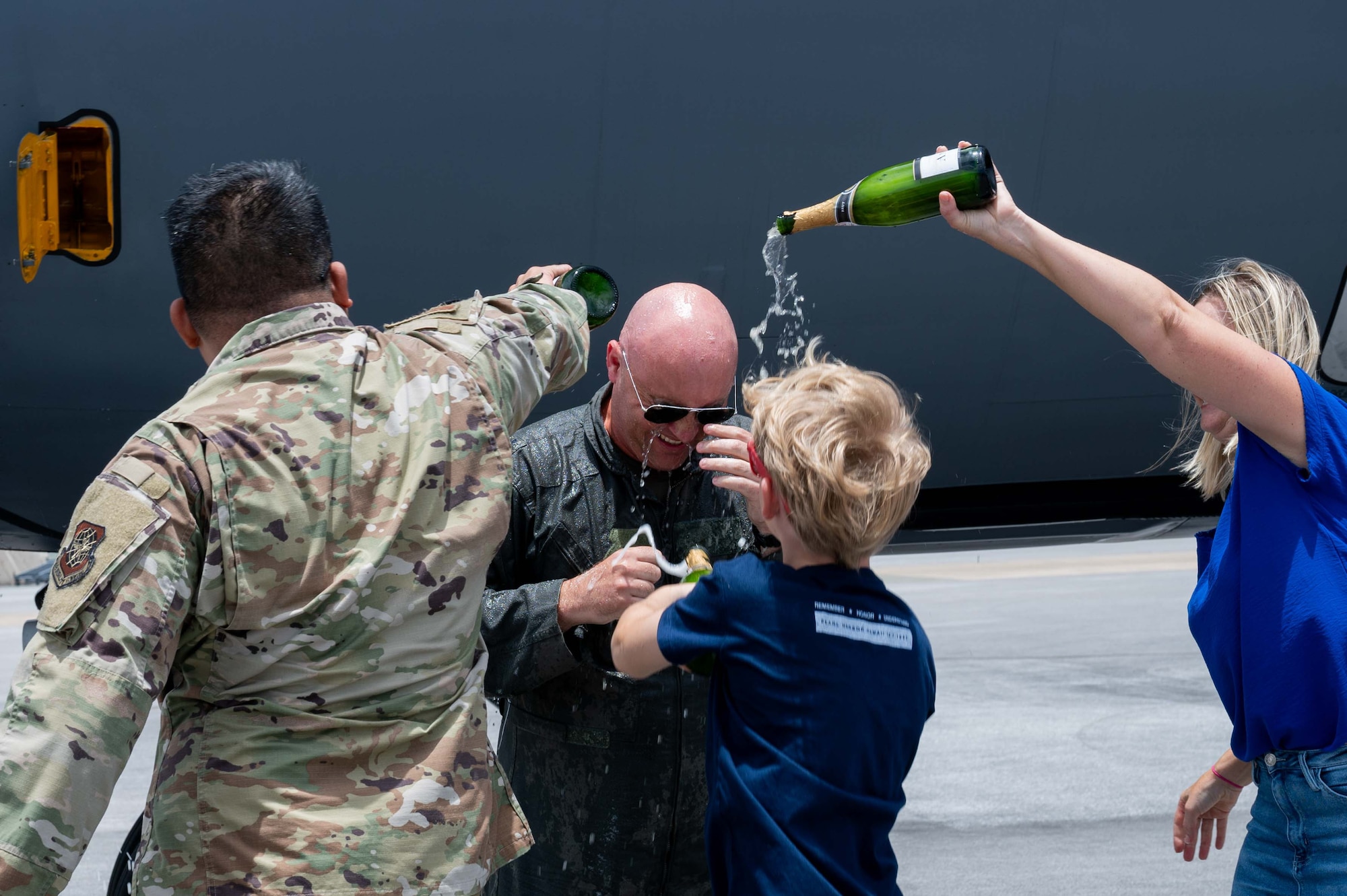 U.S. pilot has champaign poured onto him by his wife, son, and coworker