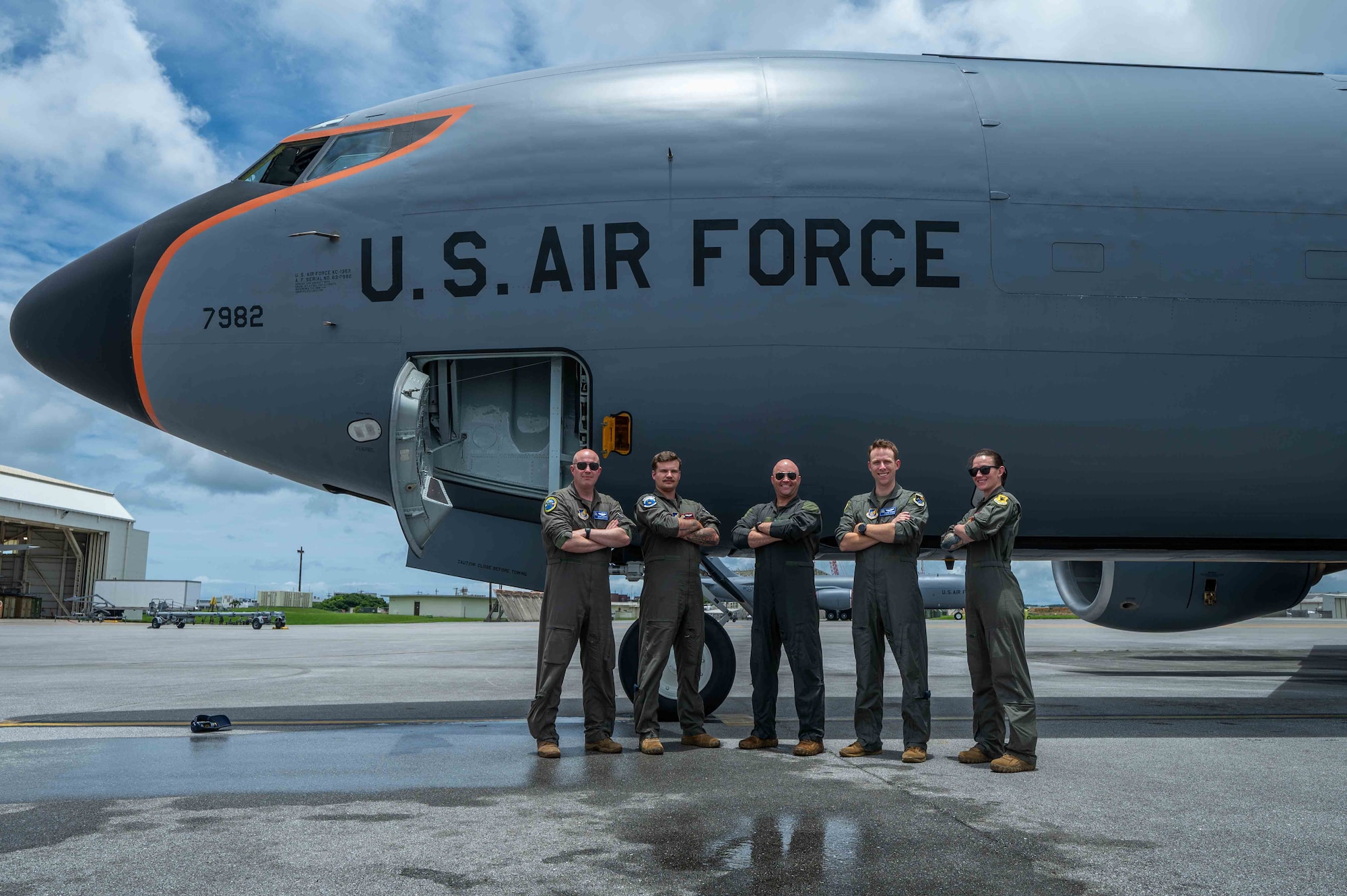 military members stand with arms crossed Infront of an aircraft