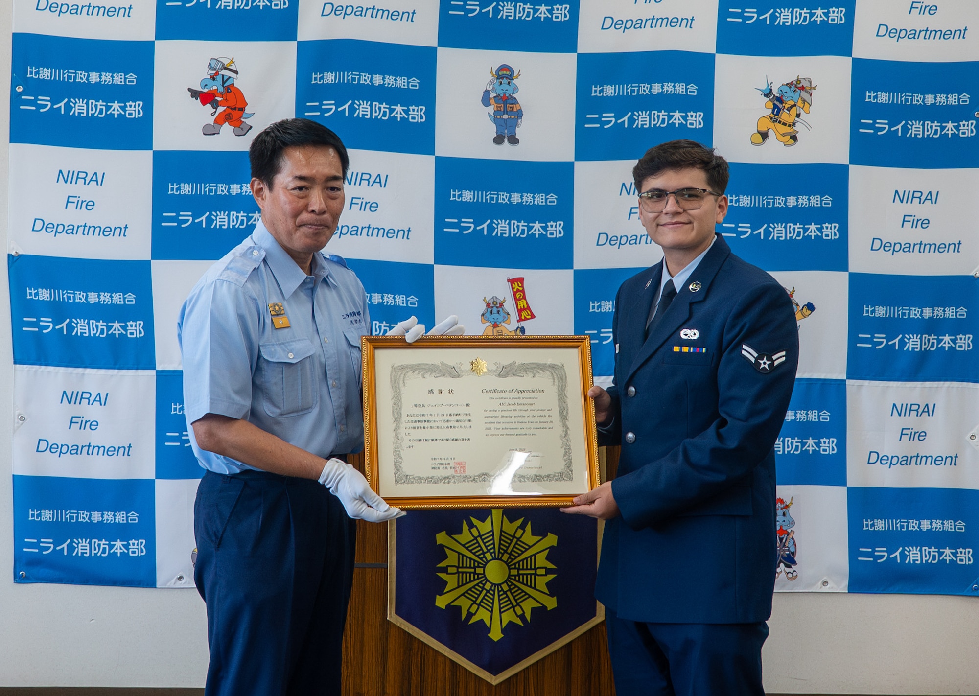 A U.S. Air Force Airman poses for a photo with a certificate of appreciation.