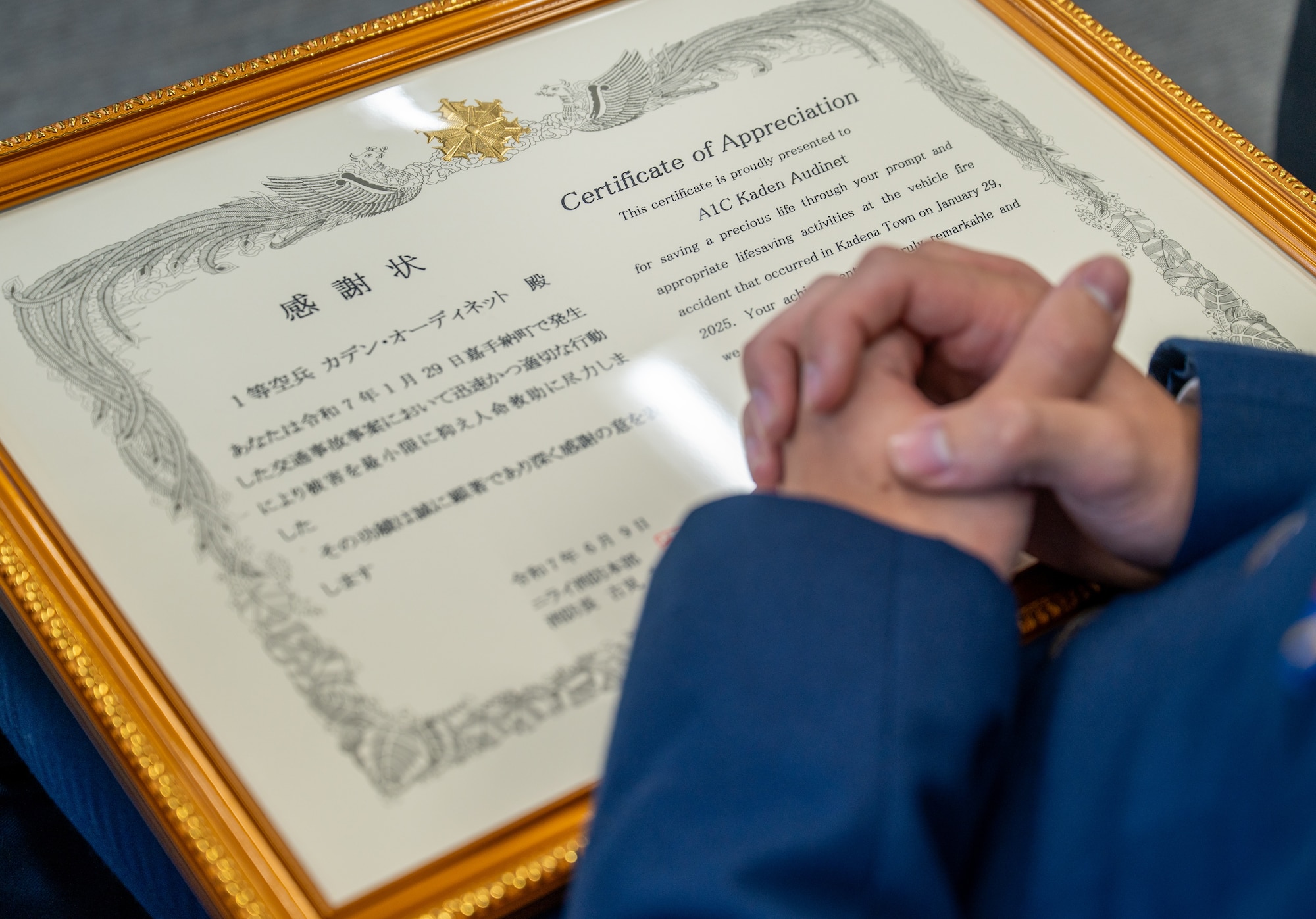A certificate of appreciation sits on the lap of a U.S. Air Force Airman.