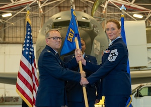 man hands flag to woman