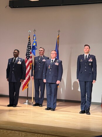 photo of four uniformed US Airmen standing on a stage