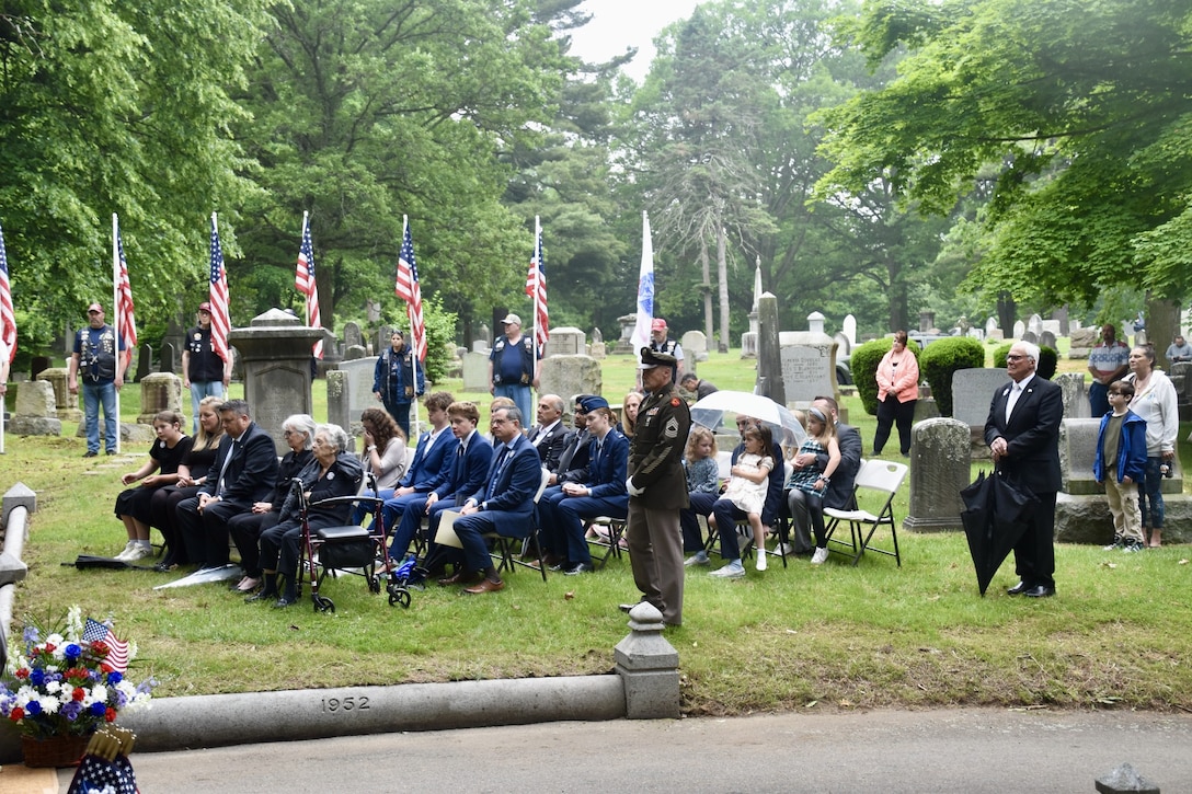 Family, citizens and uniformed personnel at funeral
