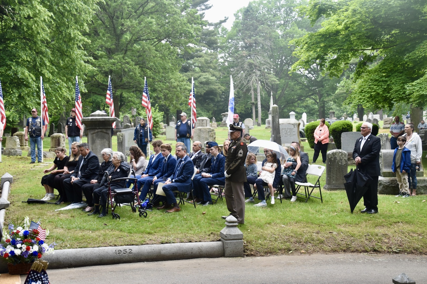 Family, citizens and uniformed personnel at funeral