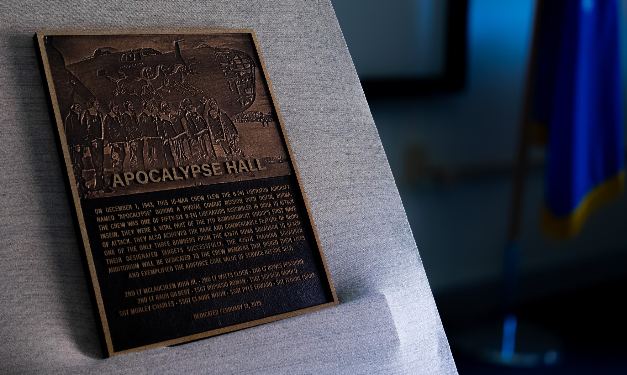 An unveiled plaque rests on the stage of the newly dedicated Apocalypse Hall at the 436th Training Squadron, June 2, 2025, at Dyess Air Force Base, Texas. he 436th TRS auditorium was named "Apocalypse Hall" after U.S. Army Air Corps members 2nd Lt. John E. McLauchlen, Tech Sgt. Harold L. Seifried and Staff Sgt. Frank J. Tedone who were crewmembers at the start of World War II attached to the 436th Bombardment Squadron.  All three men lost their lives when the B-24J Liberator “Apocalypse” was shot down in the Southwest Pacific. (U.S. Air Force photo by Master Sgt. Eboni Reams)