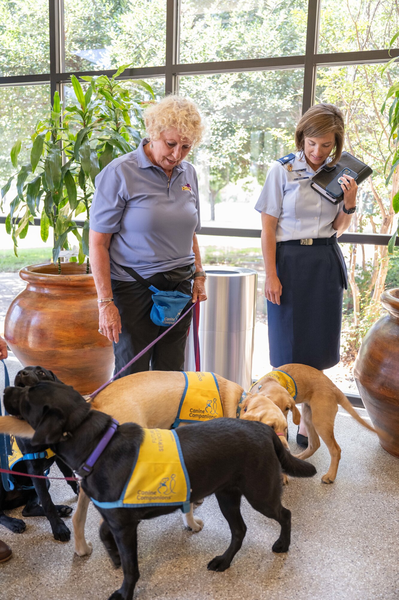 Dr. Janelle O’Connell, former Dean of the College of Health Professions at Hardin-Simmons University, and Lt. Col. Nicole Ward, 7th Healthcare Operations Squadron commander, escort future service dogs during a tour of the 7th Medical Group at Dyess Air Force Base, Texas, June 4, 2025. Dr. O’Connell, the 7th HCOS honorary commander, helped facilitate a personal management course for Dyess Airmen and has worked with Canine Companions since December 2021, to bring future service dogs to tour the 7th MDG over the years. (U.S. Air Force photo by Airman Caleb Schellenberg)